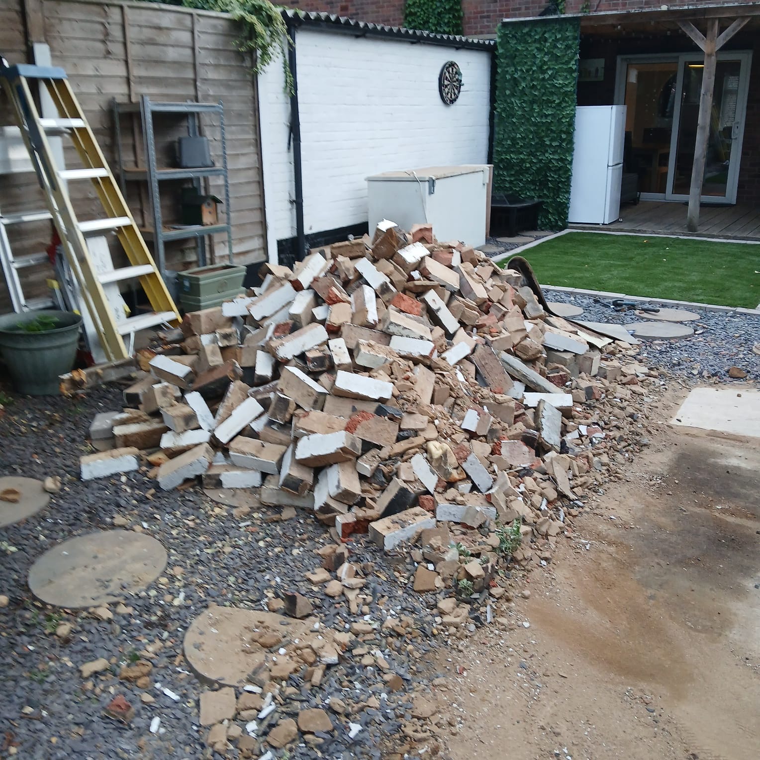 Pile of broken bricks and rubble from a garage demolition in an Essex garden