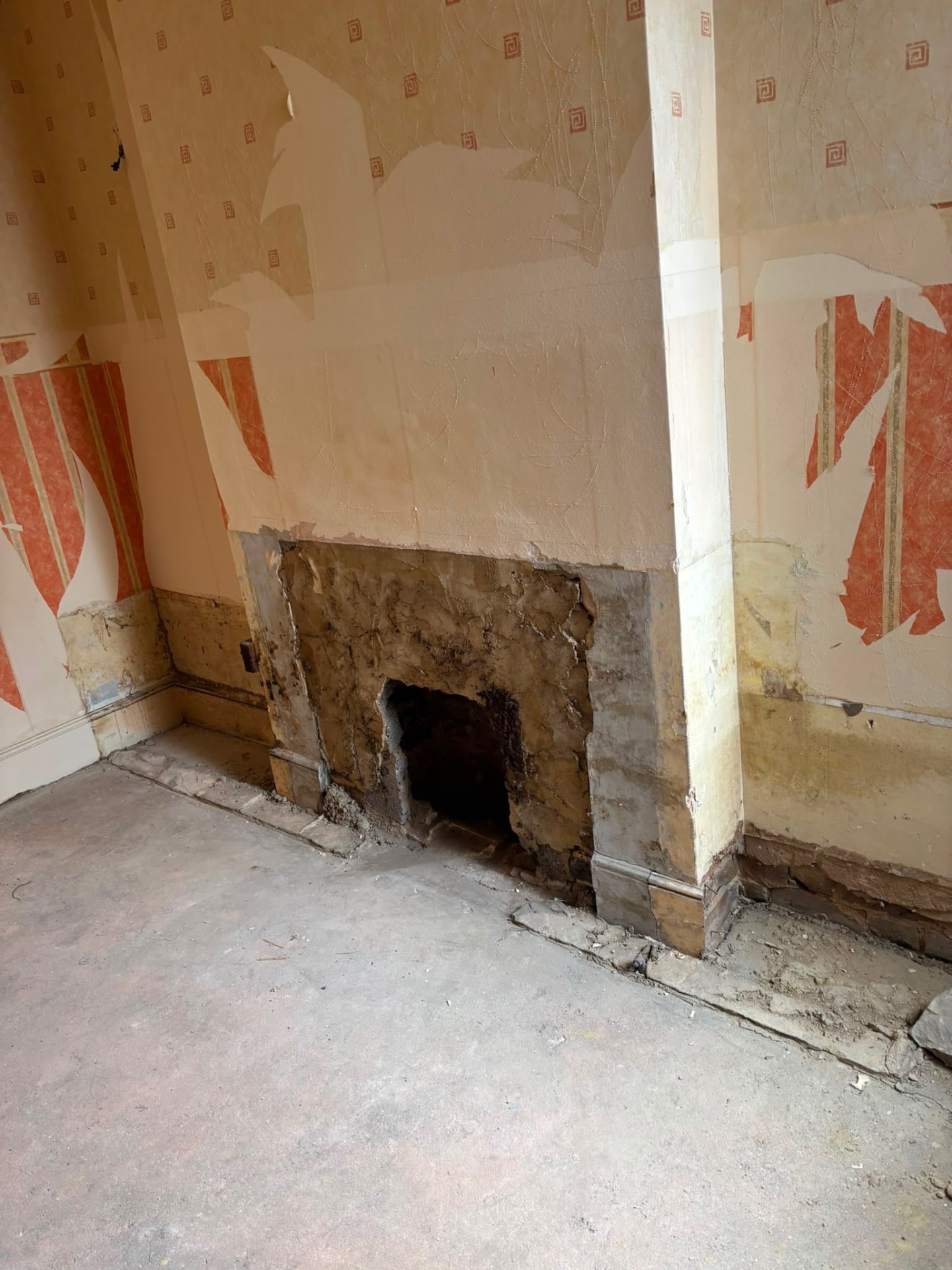 The same room with the fireplace rubble cleared and the floor swept